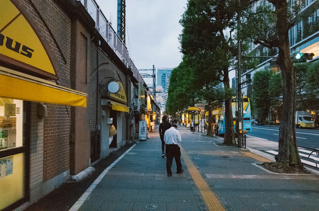 People walking on a city sidewalk at dusk