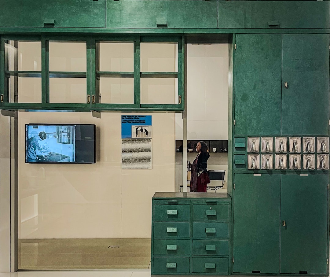 Green cabinets and a screen displaying a medical scene.